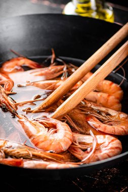 The shrimp are boiled in a pot of water. Against a dark background. High quality photo