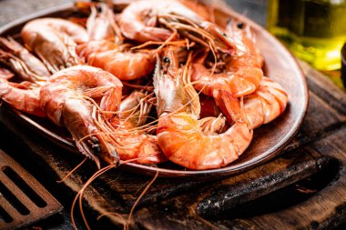 Boiled shrimp in a wooden plate. Against a dark background. High quality photo