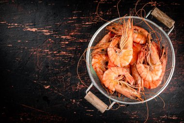 Fragrant boiled shrimp in a colander. On a rustic dark background. High quality photo