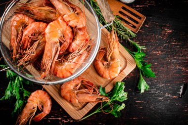 Fragrant boiled shrimp in a colander. On a rustic dark background. High quality photo