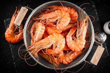 Fragrant boiled shrimp in a colander. On a rustic dark background. High quality photo