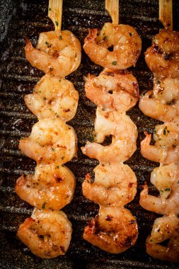 Grilled shrimp in a frying pan. On a rustic background. High quality photo