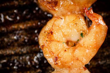 Grilled shrimp in a frying pan. On a rustic background. High quality photo