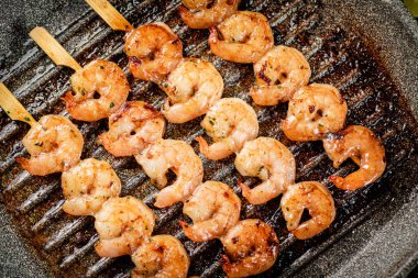 Grilled shrimp in a frying pan. On a rustic background. High quality photo