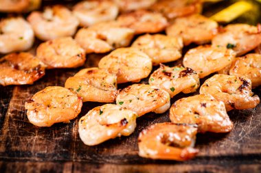 Grilled shrimp on a wooden cutting board. High quality photo