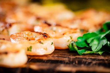 Grilled shrimp with parsley on a wooden background. High quality photo