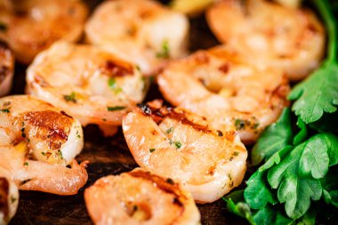 Grilled shrimp with parsley on a wooden background. High quality photo