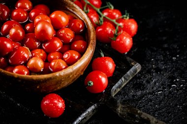 Tomatoes for marinating in a wooden plate. On a black background. High quality photo