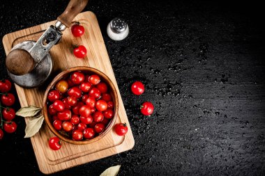 Pickling ripe tomatoes on a cutting board. On a black background. High quality photo