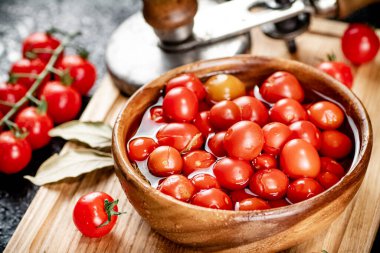 Pickling ripe tomatoes on a cutting board. On a black background. High quality photo