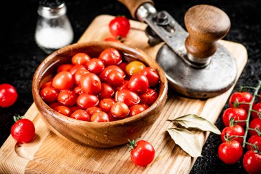 Pickling ripe tomatoes on a cutting board. On a black background. High quality photo