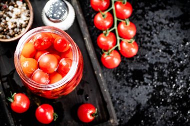 Pickling ripe tomatoes on a cutting board. On a black background. High quality photo