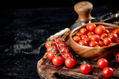 Preparation of tomatoes for pickling on a cutting board. On a black background. High quality photo