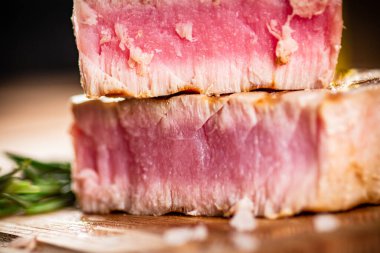 A piece of grilled tuna on a cutting board. On a wooden background. High quality photo