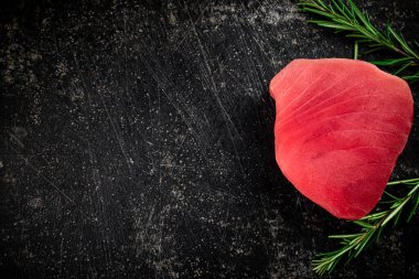 Raw tuna steak on the table. On a black background. High quality photo