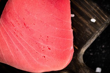 Raw tuna on a cutting board. On a black background. High quality photo