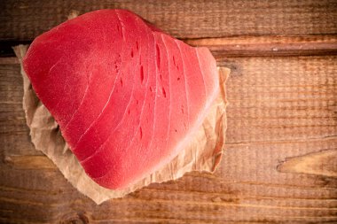 Raw tuna steak with paper on the table. On a wooden background. High quality photo