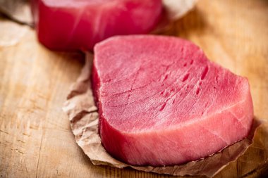 Fresh raw tuna steak on the table. On a wooden background. High quality photo