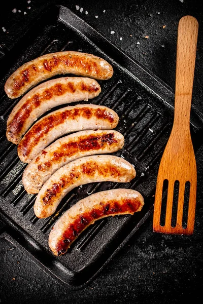 Grilled Sausages Frying Pan Wooden Spatula Black Background High Quality — Photo