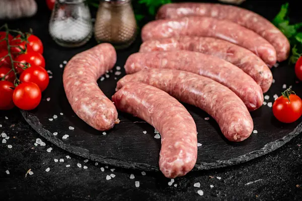 Raw Sausages Stone Board Spices Tomatoes Herbs Black Background High — Stok fotoğraf