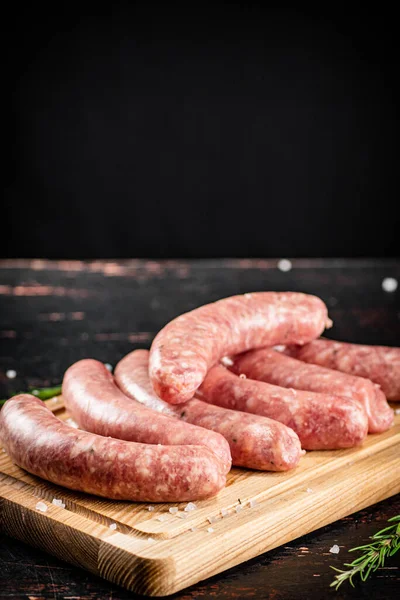 Raw Sausages Wooden Cutting Board Black Background High Quality Photo — Photo