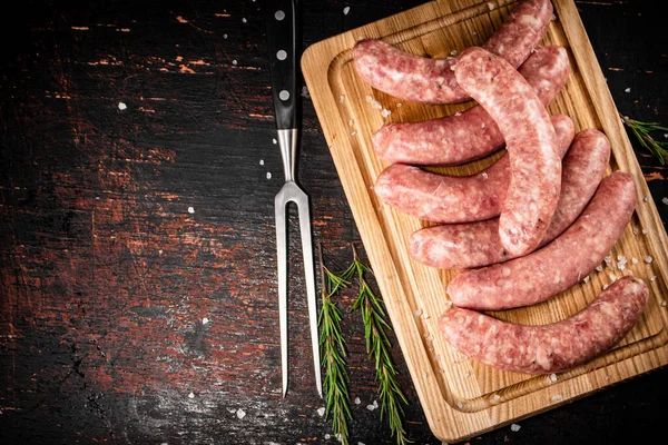 Raw Sausages Cutting Board Sprig Rosemary Rustic Dark Background High — Photo