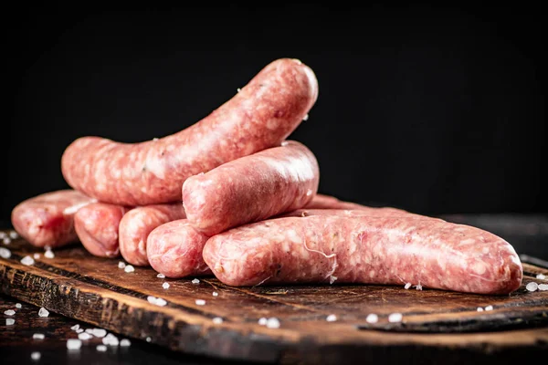 Raw Sausages Cutting Board Rustic Dark Background High Quality Photo — стоковое фото