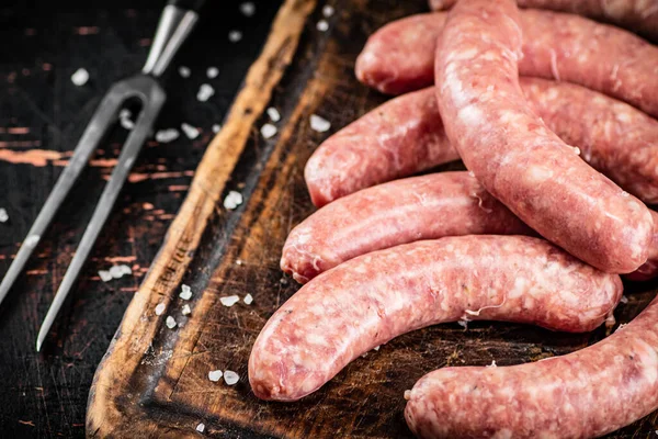 Raw Sausages Cutting Board Rustic Dark Background High Quality Photo — Stok fotoğraf