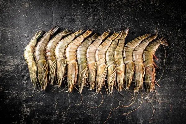 Fresh uncooked raw shrimp. On a black background. High quality photo