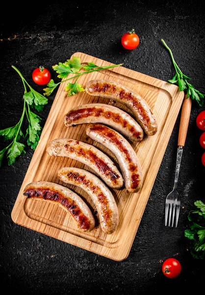 Grilled Sausages Wooden Cutting Board Parsley Tomatoes Black Background High Stockbild
