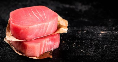 Raw tuna steaks on the table. On a black background. High quality photo