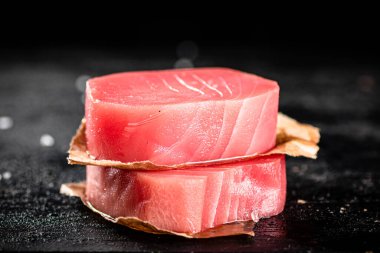 Raw tuna steaks on the table. On a black background. High quality photo