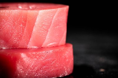 Raw tuna steaks on the table. On a black background. High quality photo