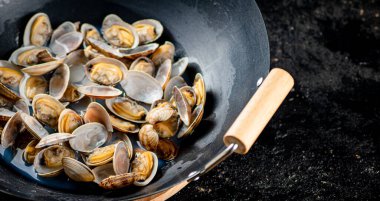 Vongole in a pot of water. On a black background. High quality photo