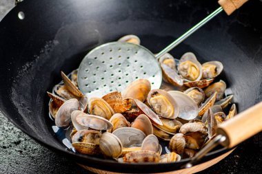 Vongole in a pot of water. On a black background. High quality photo