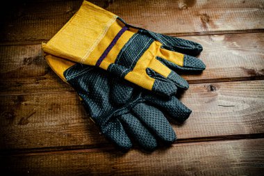 A pair of construction gloves on the table. On a wooden background. High quality photo