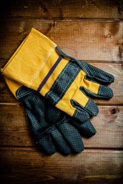 A pair of construction gloves on the table. On a wooden background. High quality photo