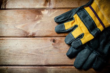A pair of construction gloves on the table. On a wooden background. High quality photo