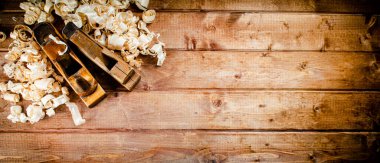 Hand planer with wooden sawdust. On a wooden background. High quality photo