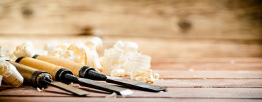 Chisel with a bunch of wood sawdust. On a wooden background. High quality photo