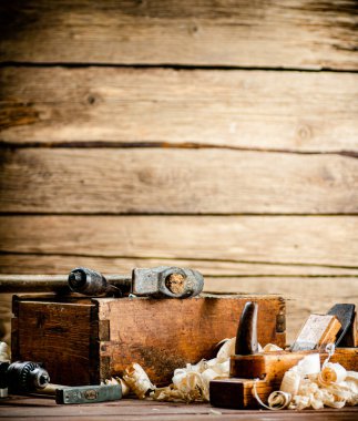 Hand planer with wooden sawdust. On a wooden background. High quality photo