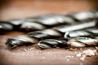 Various drill bits for drills. On a wooden background. High quality photo