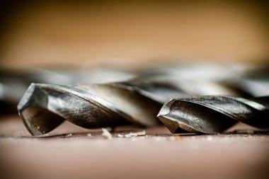 Various drill bits for drills. On a wooden background. High quality photo