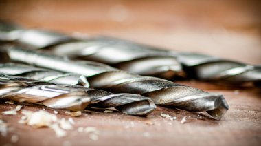 Various drill bits for drills. On a wooden background. High quality photo