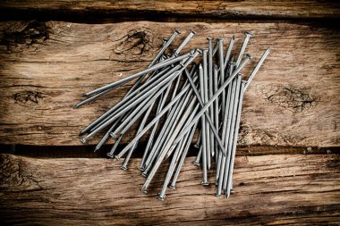 A bunch of nails on the table. On a wooden background. High quality photo