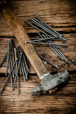 A bunch of nails on the table. On a wooden background. High quality photo