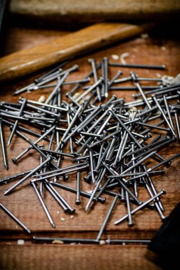 A pile of nails on the table. On a wooden background. High quality photo