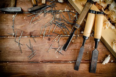 Working tool. Chisel, hammer and nails. On a wooden background. High quality photo