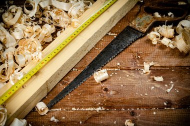 Hand saw with wooden shavings. On a wooden background. High quality photo