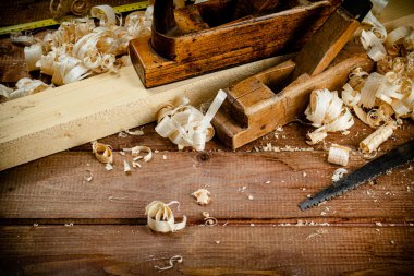 Working tool. Planer with wooden shavings. On a wooden background. High quality photo